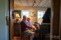 Senior male couple playing piano at home