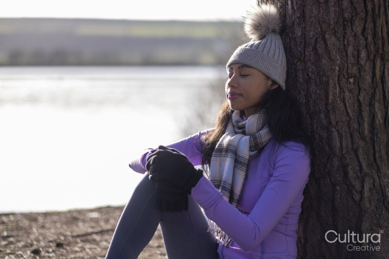 Young woman sitting against tree