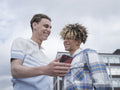 Smiling male couple using smart phone