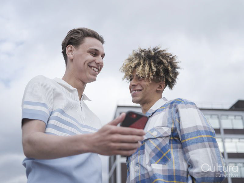 Smiling male couple using smart phone