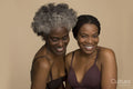 Studio portrait of two smiling women wearing lingerie