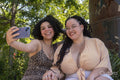 Smiling couple taking selfie in park