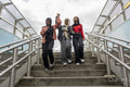 Smiling young women wearing hijabs holding hands on steps