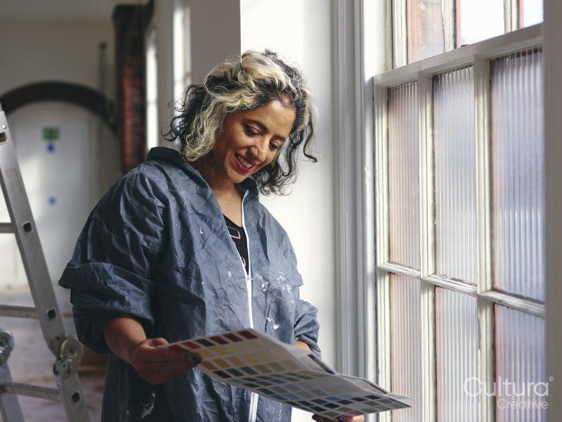 Woman looking at color swatch in loft apartment