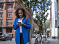 Woman using smart phone on street
