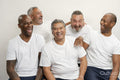 Group portrait of senior men in white t-shirts laughing against gray background