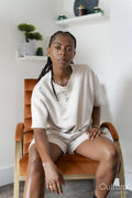 Portrait of beautiful woman looking at camera while sitting in armchair at home