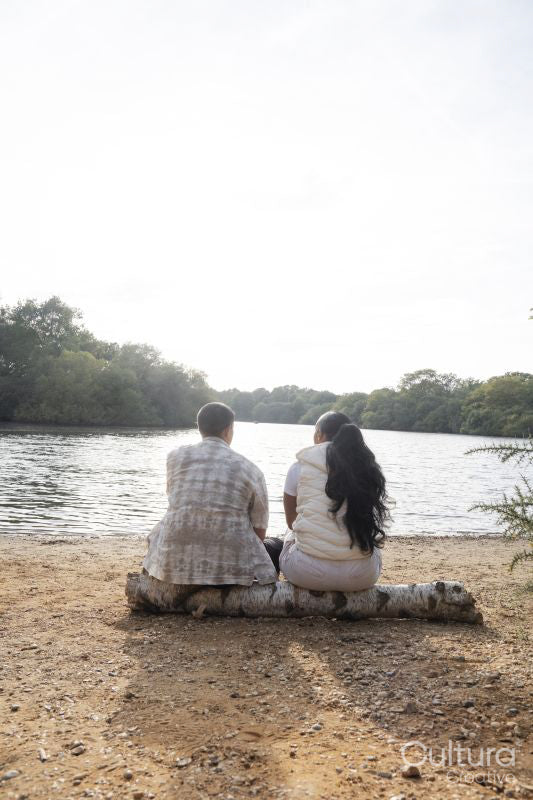 Rear view of couple sitting on lakeshore