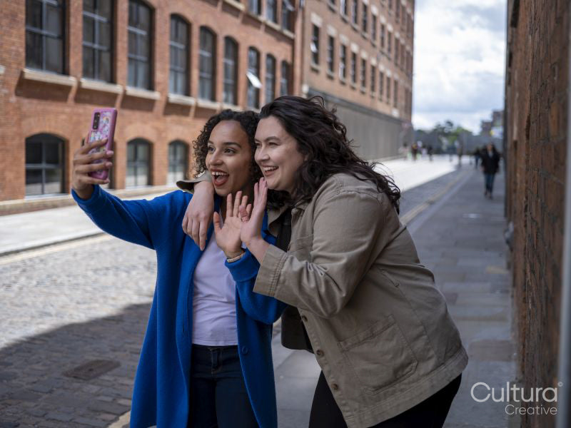 Smiling couple having video call on street