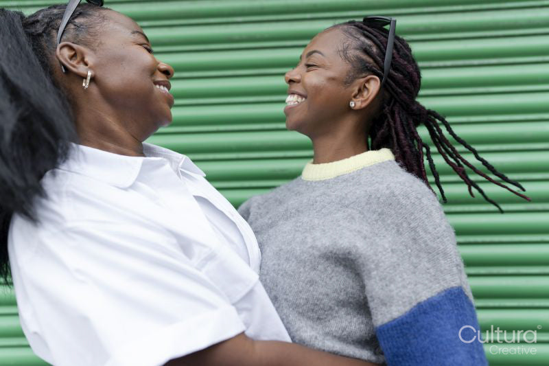 Stylish female couple smiling and hugging