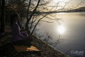 Young woman meditating at lake