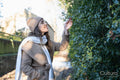 Woman in winter clothing touching tree leaves