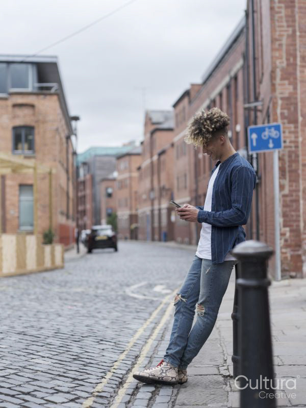 Smiling man using smart phone in city