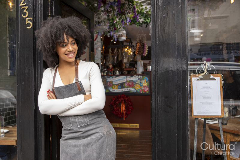 Portrait of smiling cafe owner at doorway