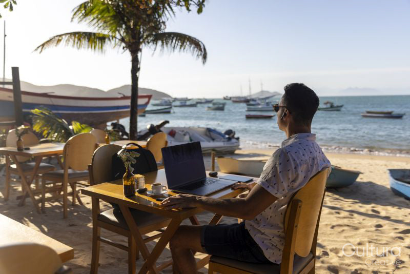 Man using laptop at beach cafe