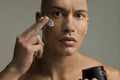Studio portrait of man applying face cream