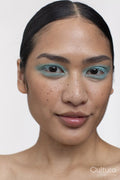 Portrait of woman with black hair and blue makeup