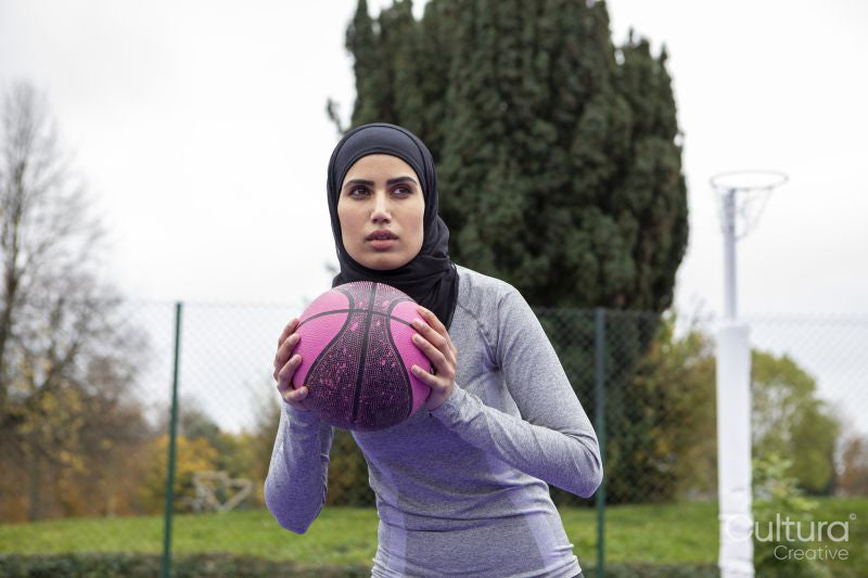 Woman in hijab playing basketball