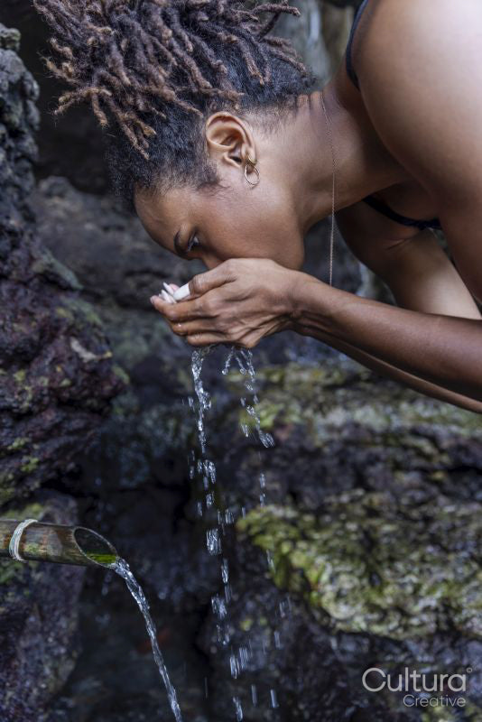 Woman drinking natural water from spring