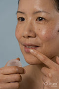 Mid adult woman applying lip balm