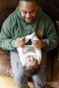 Father playing baby daughter at home