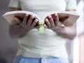 Midsection of person holding open book