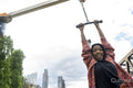 Portrait of smiling woman wearing hijab hanging on exercise machine in park
