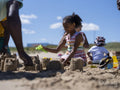Family with children building sand castles on beach