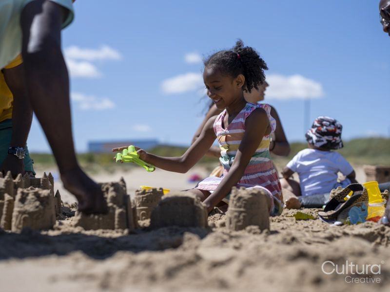 Family with children building sand castles on beach