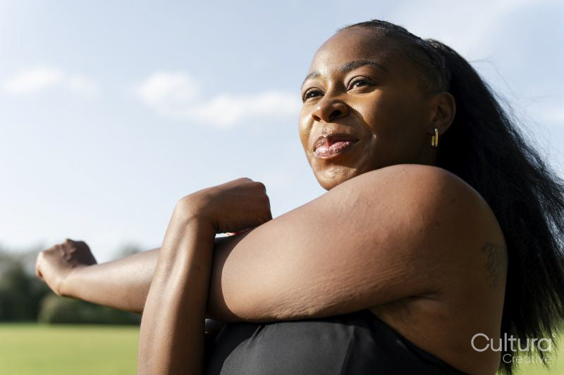 Young woman stretching in park