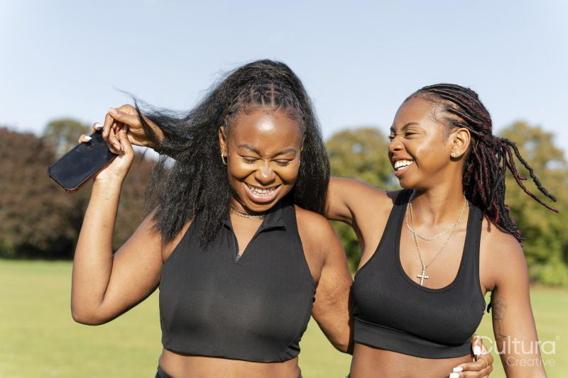 Young female friends walking in park after exercising