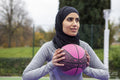 Smiling woman in hijab holding basketball ball