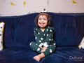 Portrait of smiling girl with Down syndrome sitting on sofa
