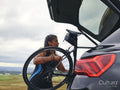 Woman taking bicycle out of car trunk