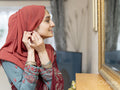Woman looking at mirror and putting on earrings