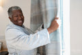 Smiling senior woman in bathrobe standing by window
