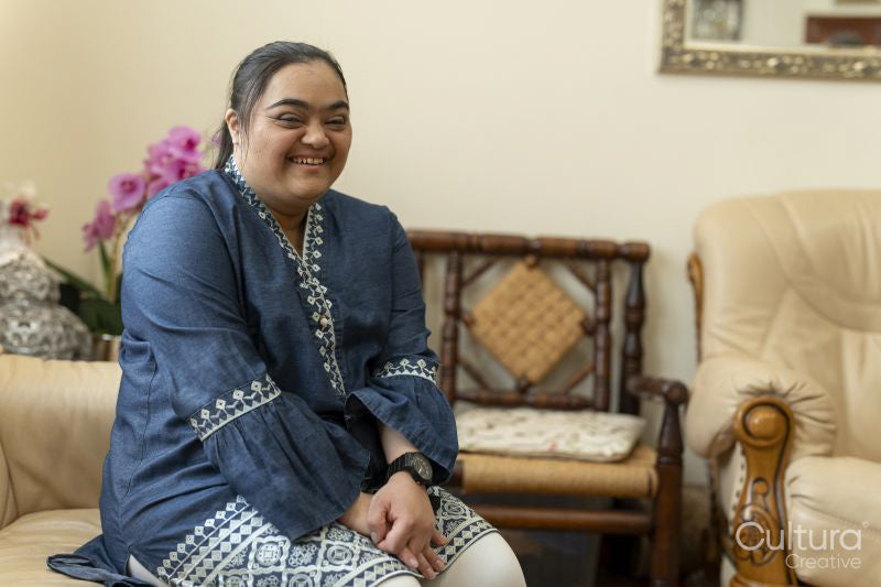 Portrait of young woman with down syndrome laughing at home