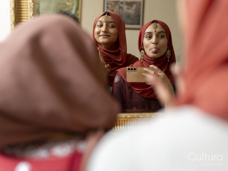 Women photographing their reflection in mirror