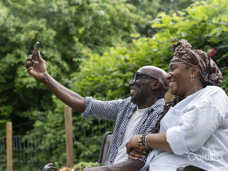 Smiling couple taking selfie after working in garden