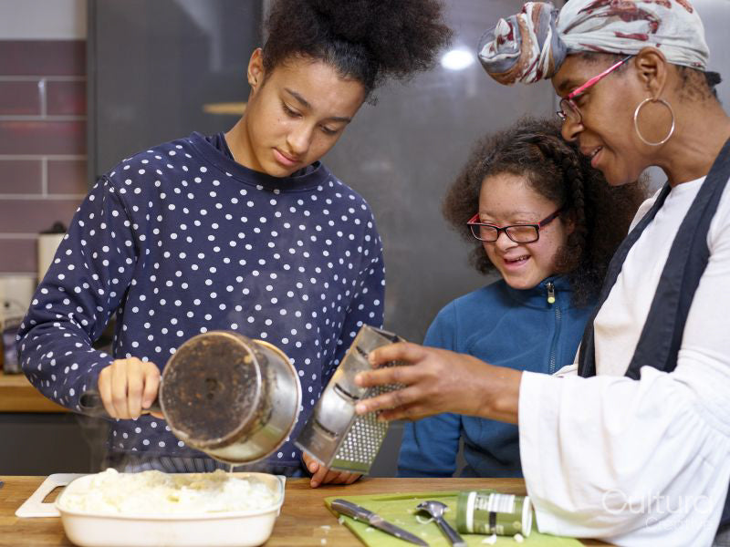 Mother with two daughters preparing food in kitchen
