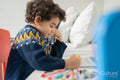 Boy coloring in coloring book at home