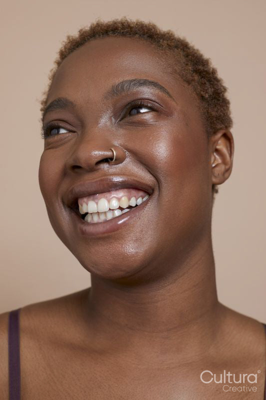 Studio portrait of smiling woman with nose ring