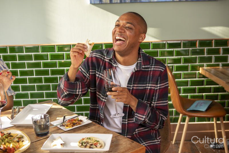 Man enjoying red wine and Me,ican food at restaurant table