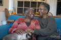 Senior couple with cat sitting on sofa