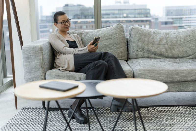Non binary person resting in office lobby