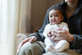 Young mother holding baby girl on lap at home