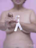 Mid section of shirtless woman with pink breast cancer awareness ribbon