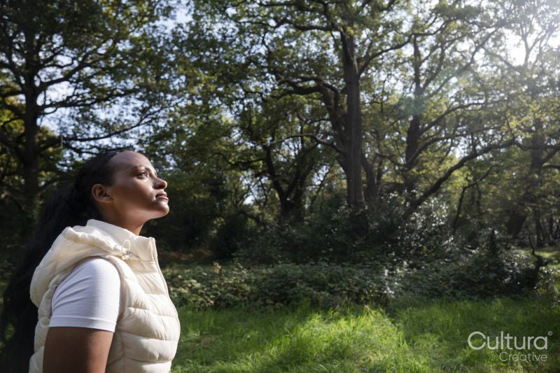 Portrait of young woman relaxing in park on sunny day