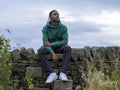 Portrait of teenage boy sitting on stone wall
