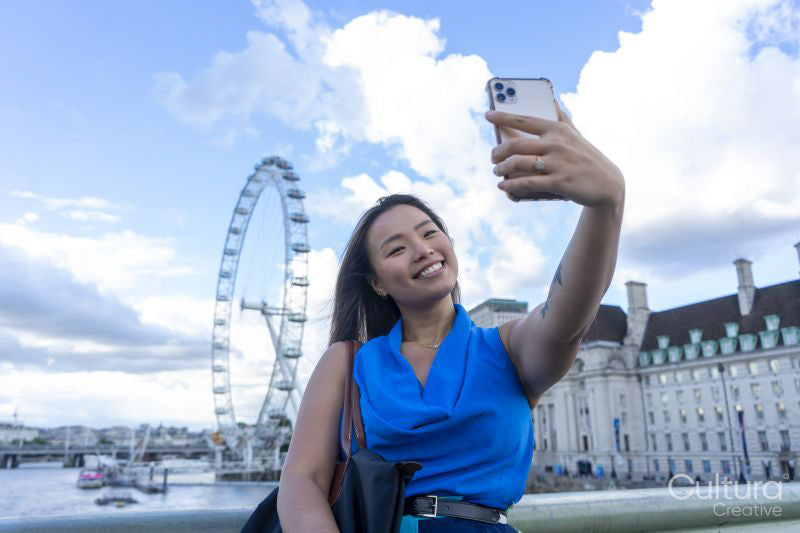 United Kingdom, London, Woman taking selfie with Millennium Wheel in background